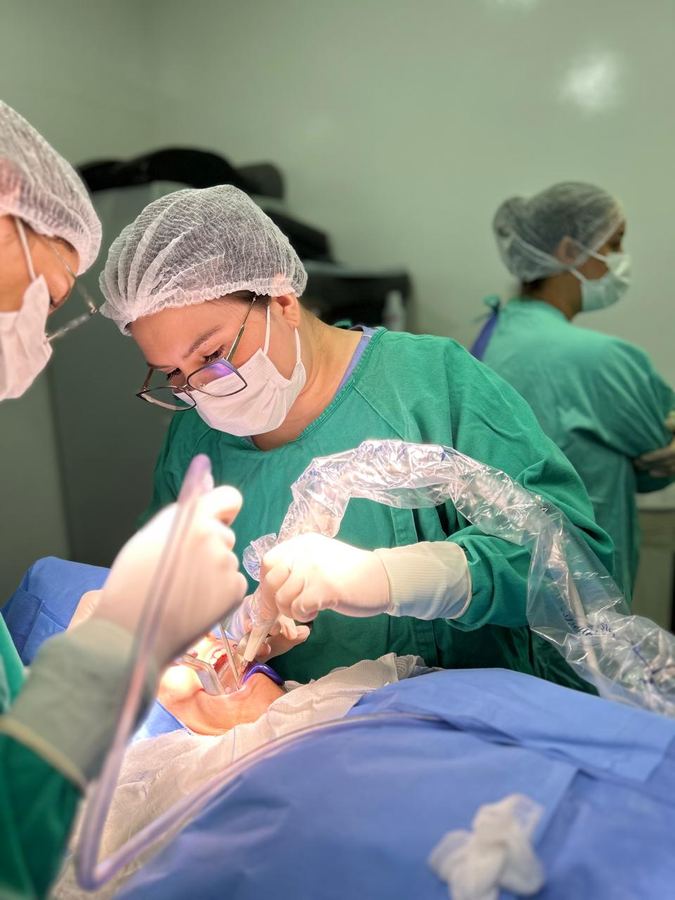 Cirurgiã-dentista da SOHD em procedimento odontológico em ambiente hospitalar, no bloco cirúrgico